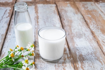 Bottle and glass of milk on wooden table