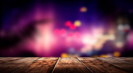 Wooden table, blurred bokeh background background. Neon light, night view, close-up. The general...