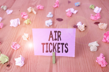 Writing note showing Air Tickets. Business concept for individual is entitled to a seat on a flight on an aircraft Colored crumpled papers wooden floor background clothespin