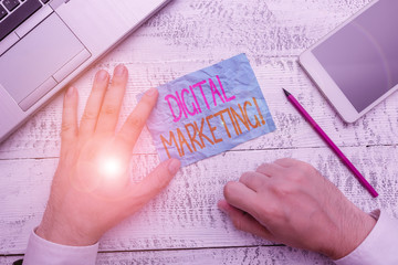 Writing note showing Digital Marketing. Business concept for market products or services using technologies on Internet Hand hold note paper near writing equipment and smartphone