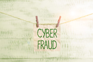 Conceptual hand writing showing Cyber Fraud. Concept meaning any crime that is committed with the use of a computer Clothespin rectangle shaped paper reminder white wood desk