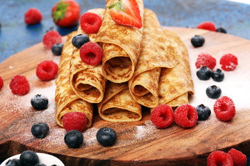 Delicious Tasty Homemade crepes or pancakes with raspberries and mint on rustic background