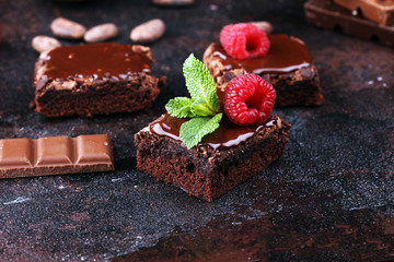chocolate brownie cake dessert with raspberries and spices on a wooden background.