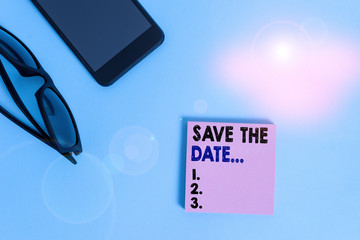 Text sign showing Save The Date. Business photo showcasing reserve the mentioned future wedding date on their calendar Dark eyeglasses colored sticky note smartphone fashion pastel background