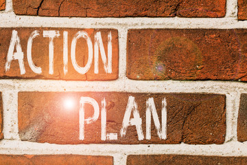 Writing note showing Action Plan. Business concept for detailed plan outlining actions needed to reach goals or vision Front view red brick wall facade background Old grunge scenery