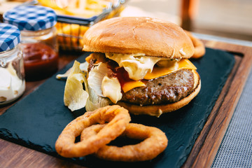 Tasty burger with beef, french fries and ketchup on plate. Fast food fries and cheeseburger