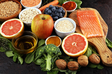 Healthy food clean eating selection: fish, fruit, vegetable, cereal, leaf vegetable on rustic background