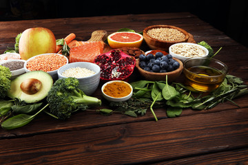 Healthy food clean eating selection: fish, fruit, vegetable, cereal, leaf vegetable on rustic background