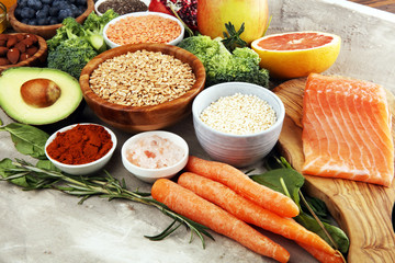 Healthy food clean eating selection: fish, fruit, vegetable, cereal, leaf vegetable on rustic background