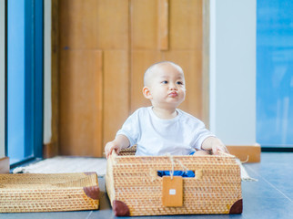 baby boy child with cancer and hair loss due to chemotherapy in basket at home.