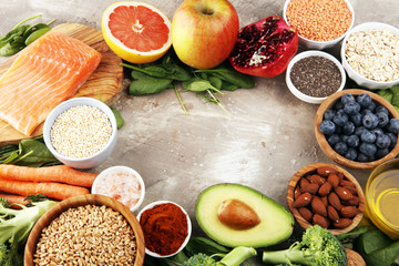 Healthy food clean eating selection: fish, fruit, vegetable, cereal, leaf vegetable on rustic background
