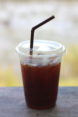 Black coffee with ice on table in cafe.