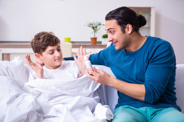 Fototapeta premium Young father caring for sick son