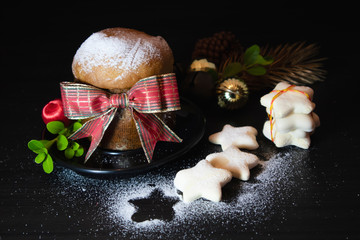 Panettone for Christmas. Traditional food decorated with bow, cookies and golden balls for Xmas. Selective focus.