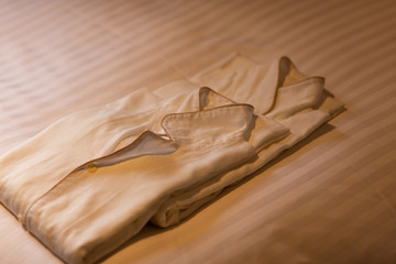 ベッドの上にあるペアのパジャマ　旅行・不倫のイメージ