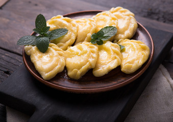 Ukrainian dumplings, pierogi or pyrohy, varenyky, vareniki, served with cottage cheese on board....