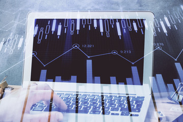 Forex graph with businessman working on laptop on background. Concept of hardworking. Multi...
