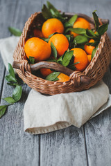 Citrus fruits in basket. Oranges, limes and lemons. Over wooden table background with copy space