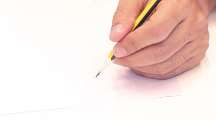 hand holding a pencil isolated on white background . Close Up on a man's hand writing on paper with a pencil  .Planning business idea background . leave note or message concept.