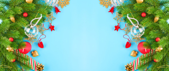 Fototapeta na wymiar Christmas background with fir branches, various christmas decorations, colored garlands and beads, on a blue background. Christmas decoration. Christmas background. Space for text.