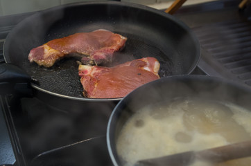 Meat and pastas cooking with pan smoking kitchen