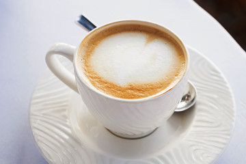 Fototapeta premium A cup of fresh cappuccino in caffe close-up
