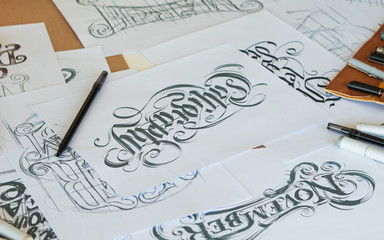 Typography Calligraphy artist designer drawing sketch writes letting spelled pen brush ink paper table artwork.Workplace design studio.