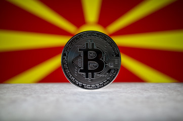 Physical silver version of Bitcoin (BTC) and Macedonia Flag on the background. Conceptual image for investors in cryptocurrency and Blockchain Technology.