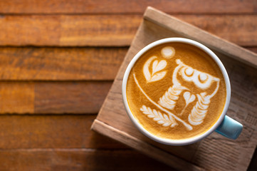 Latte art coffee on wooden table