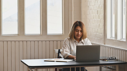 Attractive woman using laptop computer in cafe.