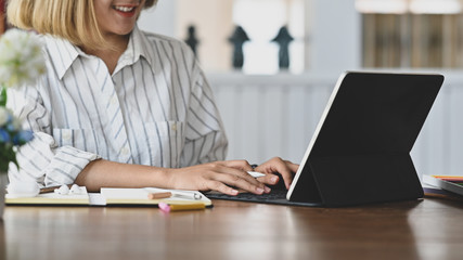 Closeup young female typing digital tablet.