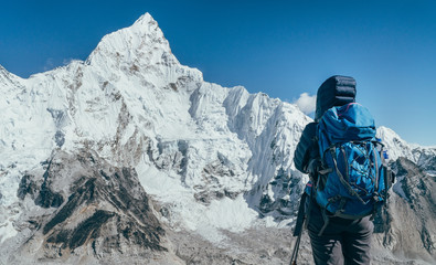 Young hiker backpacker female taking brake in hike walking enjoying Khumbu Glacier. High altitude Everest Base Camp route near Gorakshep,Nepal. Nuptse 7861m on background. Active vacations concept - obrazy, fototapety, plakaty
