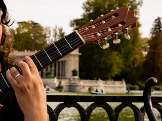 singer-songwriter with guitar in the lake-side retreat park - obrazy, fototapety, plakaty