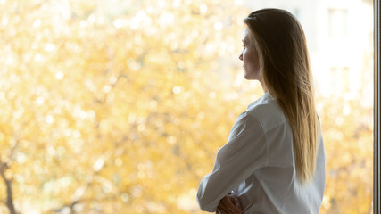 Back view of pensive businesswoman look in distance thinking