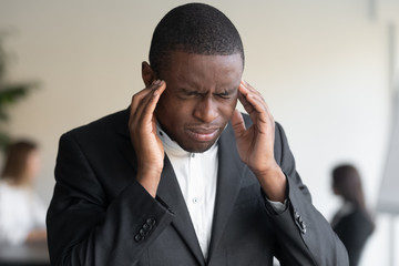 Close up of stressed biracial businessman suffering from headache