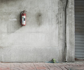 Fire extinguisher on texture of old gray concrete wall for background