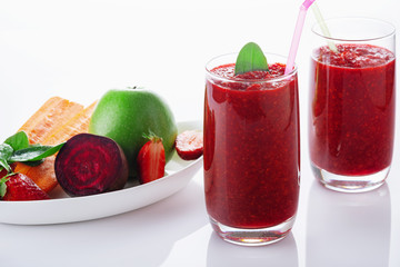 Detox smoothie from apple, beet, carrots, strawberry and spinach in a glass on a white background. Ingredients for a detox smoothie.  High key. Selective focus.