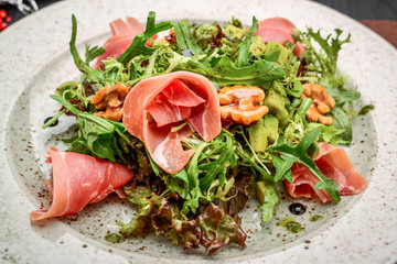 salad with parma ham jamon , tomatoes and arugula