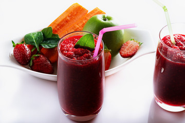 Detox smoothie from apple, beet, carrots, strawberry and spinach in a glass on a white background. Ingredients for a detox smoothie.  High key. Selective focus.