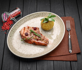 Pork steak on the bone with cherry-ginger sauce with ingredients on messy sackcloth background.