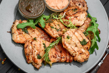 Tasty Grilled chicken fillet and chili peppers on a plate on the table. horizontal view from above