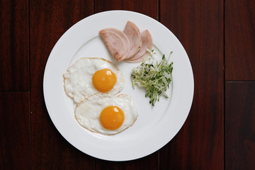 Food: fried eggs, ham and salad.