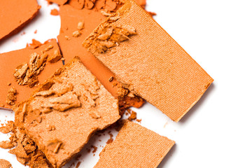 A broken orange eye shadow smear make up palette isolated on a white background. Top view, flat lay. Copy space for your text