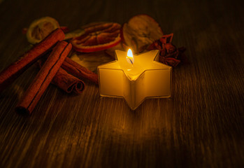candle in front of dry fruits at christmas time