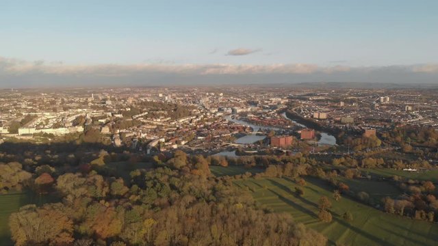 Aerial view of city of Bristol at golden hour, showing harbourside and park during Autumn