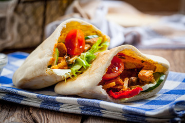 Fried chicken meat with vegetables in pita bread - obrazy, fototapety, plakaty