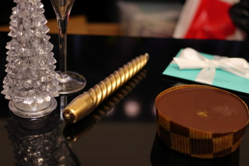 テーブルの上のケーキとクリスマスツリーとグラスとろうそくと白い薔薇	