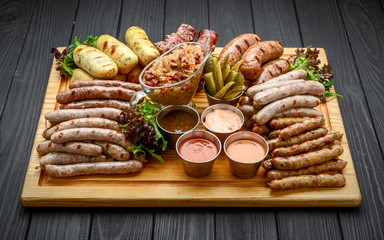 Grilled sausages with glass of beer on a wooden table