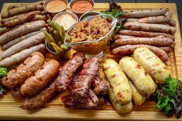 Grilled sausages with glass of beer on a wooden table