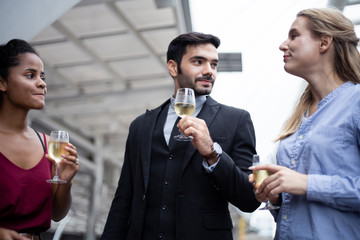 Group of business people celebrate by drinking wine.